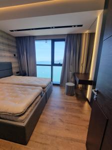 a bedroom with a bed and a desk with a window at Premium apartment in Porta Batumi Tower in Batumi