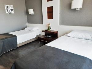 two beds in a hotel room with white sheets at Dedepark Hotel in Eskisehir