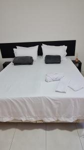 1 cama blanca con 2 almohadas en Residencial do Centro en Niterói