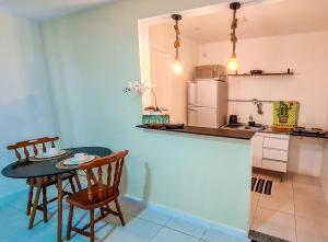 uma cozinha com uma mesa e cadeiras e um frigorífico em Residencial do Centro em Niterói