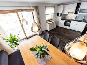 une salle à manger avec une table et une cuisine dans l'établissement Holiday apartment in Seis am Schlern, à Alpe di Siusi