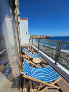 Duas cadeiras e uma mesa numa varanda com vista para a praia em Eros OceanView Attic em Santa Cruz de Tenerife
