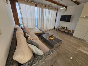 uma sala de estar com um sofá e uma mesa em Eros OceanView Attic em Santa Cruz de Tenerife