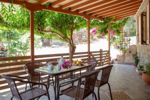 una mesa y sillas en un patio con un árbol en Elena’s House Sivota Lefkadas en Sivota