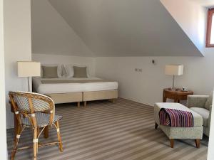 a bedroom with a bed and a chair and a couch at Hotel Glavovic in Lopud
