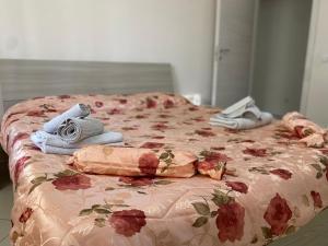 ein Bett mit Kleidung und Handtüchern darüber in der Unterkunft Appartamento Casa vacanza fronte mare in Venetico