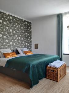 a bedroom with a large bed with a green blanket at Logement Hartsuiker in Hoogeveen