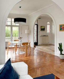 uma sala de estar com um sofá e uma mesa em La Feuilleraie - Maison de charme avec piscine em Compiègne
