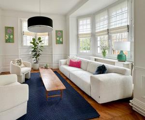 uma sala de estar com um sofá branco e uma mesa em La Feuilleraie - Maison de charme avec piscine em Compiègne