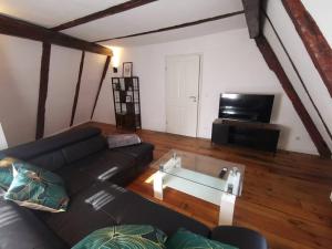 un soggiorno con divano nero e TV di Wohnung mit hist. Altstadt Charme a Nördlingen