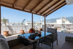 un tavolo con una ciotola di frutta in cima a un balcone di SkyVista Penthouse a Kalamáta