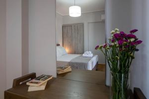 una camera da letto con un letto e un tavolo con dei fiori di SkyVista Penthouse a Kalamáta