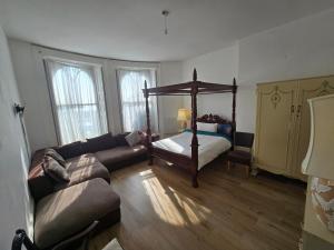 a living room with a bed and a couch at Studio next to port, cliffs, with parking in Kent