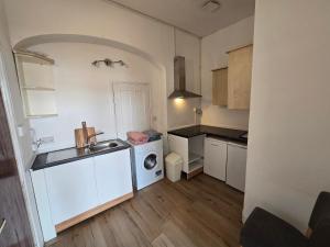 a small kitchen with a sink and a washing machine at Studio next to port, cliffs, with parking in Kent