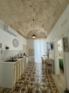 eine Küche mit einem Waschbecken und einem Tisch in einem Zimmer in der Unterkunft Petali Rosa - Dimora Verde in Polignano a Mare