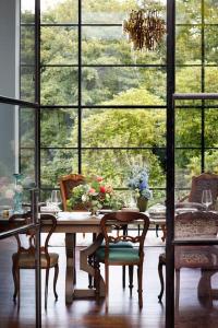 a dining room with a table and chairs and windows at Dripsey Castle Estate in Cork