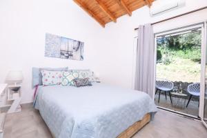 a bedroom with a bed and a sliding glass door at Casa Niovi, Acharavi in Acharavi