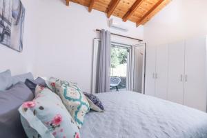 a bedroom with a bed with pillows and a window at Casa Niovi, Acharavi in Acharavi