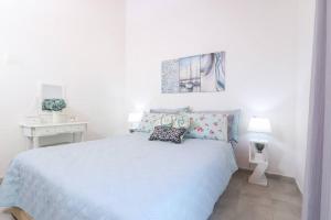 a white bedroom with a white bed with pillows at Casa Niovi, Acharavi in Acharavi