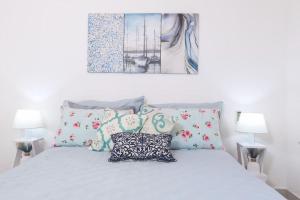 a bedroom with a white bed with pillows and a painting at Casa Niovi, Acharavi in Acharavi +28 photos