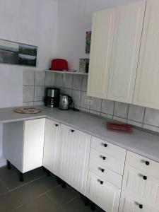 a kitchen with white cabinets and a counter top at Stadtmitte-Iserlohn in Iserlohn