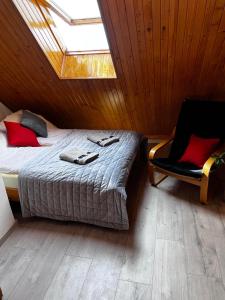 um quarto com uma cama com uma clarabóia e uma cadeira em Szyper 2 em Jastarnia