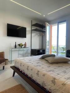 a bedroom with a bed and a television on the wall at B&B Perla sul mare in Moneglia