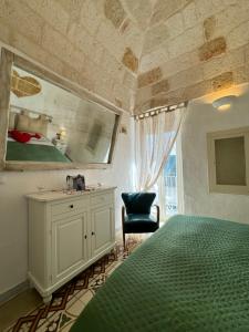 Schlafzimmer mit einem Bett, einem Waschbecken und einem Spiegel in der Unterkunft Petali Rosa - Dimora Verde in Polignano a Mare