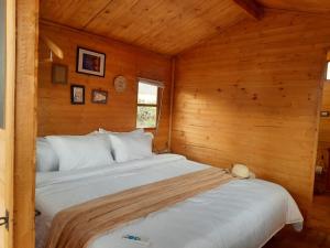 1 dormitorio con 1 cama en una cabaña de madera en El Glamping de Calixto, Villa de Leyva, en Sáchica