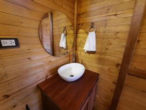baño con lavabo en una cabaña de madera en El Glamping de Calixto, Villa de Leyva, en Sáchica
