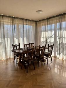 a dining room with a table and chairs and windows at Parkside Apartments Praha in Prague