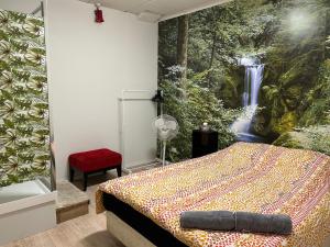 a bedroom with a bed with a waterfall mural on the wall at Sky World Cozy Home in Auckland
