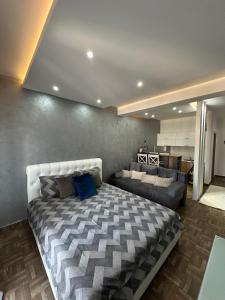 a bedroom with a large bed and a couch at Deluxe Apartments & Spa in Ulcinj