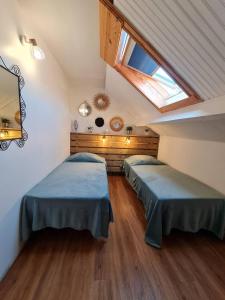 a attic room with two beds and a skylight at Maison spacieuse avec cheminée à Dives-sur-Mer in Dives-sur-Mer