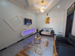 a living room with a couch and a tv at Racvity Homes Limited in Awka