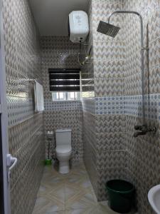 a bathroom with a toilet and a shower and a sink at Racvity Homes Limited in Akwa