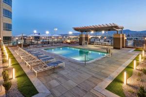 a swimming pool on the roof of a building with chairs and a patio at Courtyard By Marriott El Paso Downtown/Convention Center in El Paso