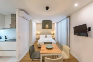 ブラガにあるBraga Center Apartments - Rua do Anjoのベッド、テーブル、キッチンが備わる客室です。