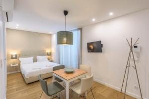 a bedroom with a bed and a table and chairs at Braga Center Apartments - Rua do Anjo in Braga