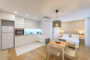 a bedroom with a bed and a table and a kitchen at Terro Collection - Anjo in Braga