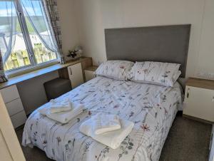 - une chambre avec un lit et des serviettes dans l'établissement 11 Meadow View, à Newquay