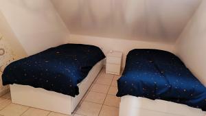 Kleines Zimmer mit 2 Betten und blauer Decke in der Unterkunft Appartement les argousiers in Oye-Plage