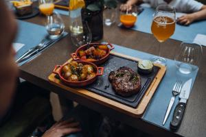 ein Tisch mit einem Steak und einem Teller Essen in der Unterkunft Gabija Hotel SPA & Conferences in Palanga