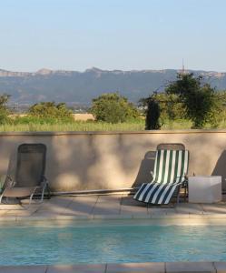 - deux chaises assises à côté de la piscine dans l'établissement Au Epicéah, logement à la campagne, à Valence