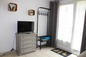 a living room with a television on a dresser at Au Epicéah, logement à la campagne in Valence
