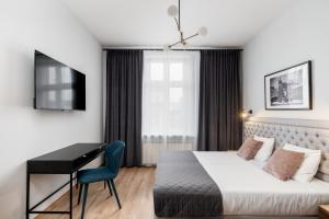 een hotelkamer met een bed en een bureau bij Wawel Apartments - Old Town in Krakau
