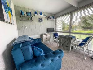 a living room with a blue couch and a table at Lovely 4 Berth Chalet In The Coastal Village Of Heacham, Ref 92018cs in Heacham