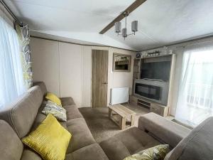 a living room with a couch and a flat screen tv at Lovely Caravan With Decking At Manor Park In Hunstanton Ref 23091t in Hunstanton