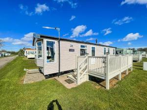 a tiny house with a porch on a grass field at 6 Berth Caravan With Decking At Sunnydale Holiday Park Ref 35243kg in Louth
