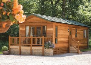 a large wooden cabin with a large deck at Crake Valley in Torver